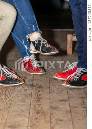 People legs with bowling shoes standing on old wooden floor 127243830