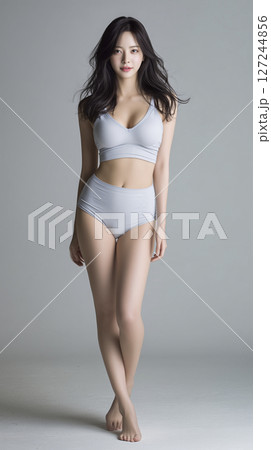 Woman is wearing a grey bikini top and bikini bottoms 127244856