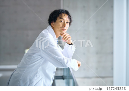 病院の廊下に立つ白衣の男性医師 127245228
