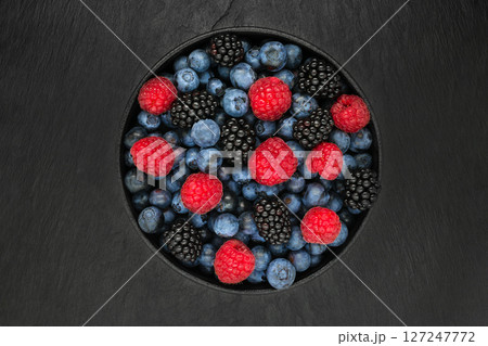 Various berries in round and black cast iron bowl Various berries in round and black cast iron bowl 127247772