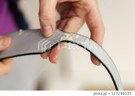 Womans hand holding shabby handle diaper bag. Closeup. Selective focus. 127249135