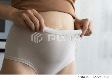 Pregnant woman wearing panties with high waist. Closeup. Pregnant woman wearing panties with high waist. Closeup. 127249508