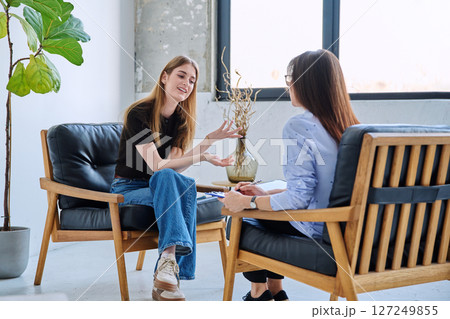 Young smiling girl patient in therapy session with social mental therapist 127249855
