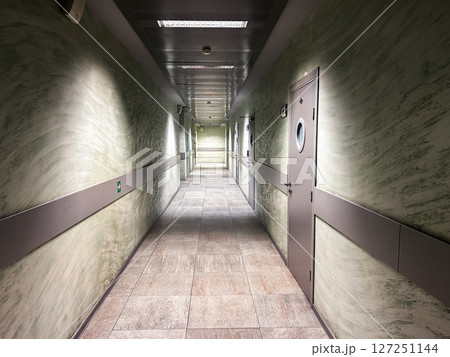 Empty office hallway with geometric lighting patterns on polished floors. Business lifestyle content 127251144