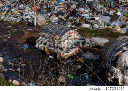 Plastic waste and other debris accumulate at a landfill site, posing significant challenges to environmental management and recycling efforts 127251413
