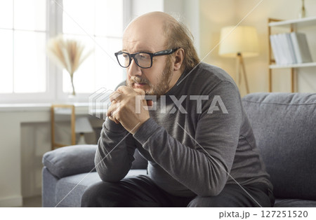 Senior alone unhappy old man sitting on sofa at home, feeling lonely retired grandfather worrying 127251520