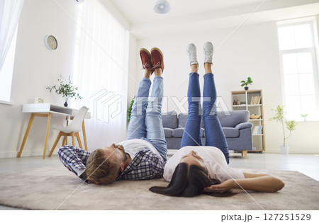 Family couple having a weekend and relaxing lying on the floor with their legs up Family couple having a weekend and relaxing lying on the floor with their legs up 127251529