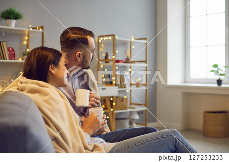 Married Couple Embracing On Sofa At Home 127253233