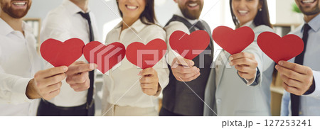 Group of smiling business people holding red hearts, close-up Group of smiling business people holding red hearts, close-up 127253241