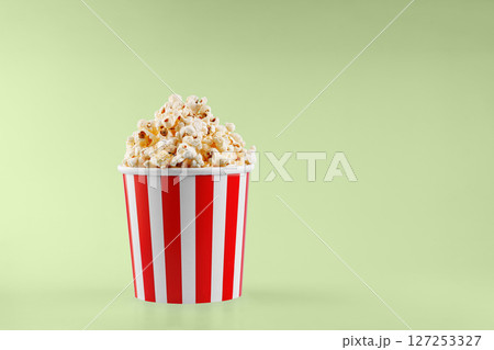 Classic red striped popcorn cardboard cup on Green background Classic red striped popcorn cardboard cup on Green background 127253327