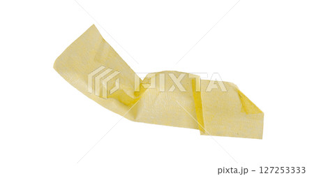 Yellow painter's tape isolated on white background, macro. Torn, crumpled, twisted strips of yellow painter's tape on white background 127253333