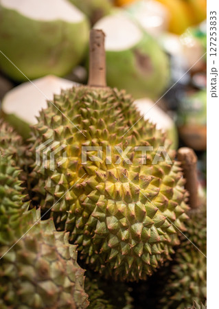 Durian fruits on supermarket shelf ready for customer selection, close up. Grocery stalls in Asia Durian fruits on supermarket shelf ready for customer selection, close up. Grocery stalls in Asia 127253833
