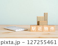 駅近物件と書かれたブロック、不動産の模型、電卓 127255461