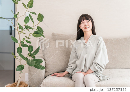 自宅のリビングでくつろぐ笑顔の若いアジア人女性 127257533