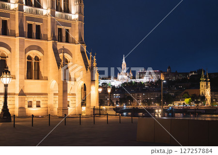Illuminated Hungarian Parliament Building, Matthias Church, and Fisherman's Bastion at night, with the Danube River and reflections enhancing the scene. 127257884