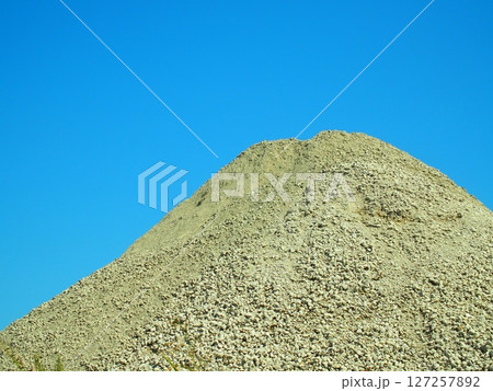 建築資材置き場の砂利の山と青空	 127257892