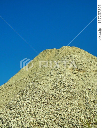 建築資材置き場の砂利の山と青空	 127257893