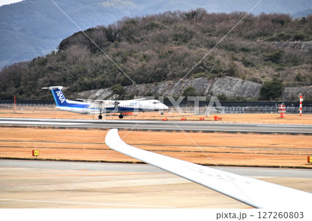 夕暮れの滑走路を走行するプロペラ機（長崎空港） 127260803