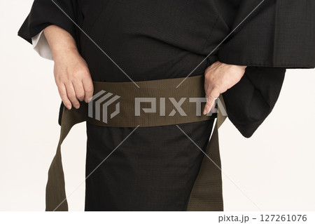 男着物を自分で着付ける男性 自装 帯を巻く手元 男着物を自分で着付ける男性 自装 帯を巻く手元 127261076