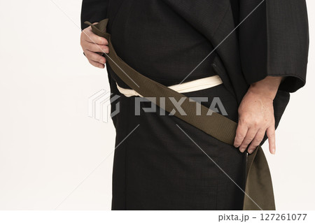 男着物を自分で着付ける男性 自装 帯を体の前で結ぶ 男着物を自分で着付ける男性 自装 帯を体の前で結ぶ 127261077