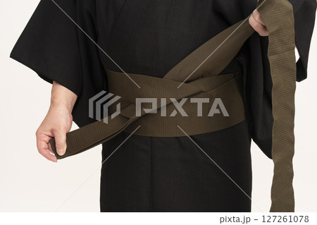 男着物を自分で着付ける男性 自装 帯を体の前で結ぶ 男着物を自分で着付ける男性 自装 帯を体の前で結ぶ 127261078