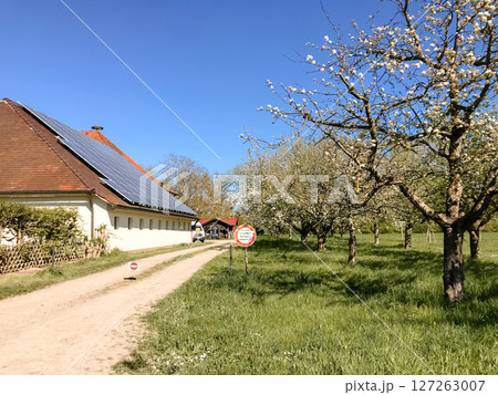 A house with a red roof and a white building next to it 127263007