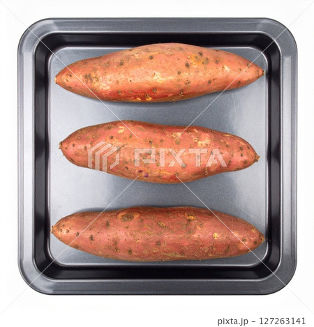 Three Red Sweet Potatoes on a Dark Grey Baking Sheet Three Red Sweet Potatoes on a Dark Grey Baking Sheet 127263141
