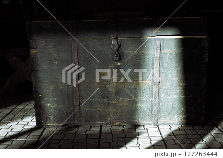 Old green wooden chest illuminated by sun beam Old green wooden chest illuminated by sun beam 127263444