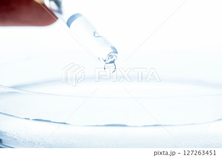 Petri dish and pipette with transparent liquid drop 127263451