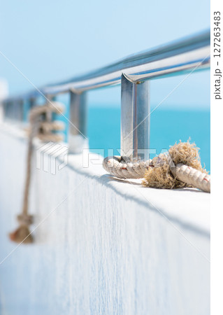 Ship railing with rope and blue sea Ship railing with rope and blue sea 127263483