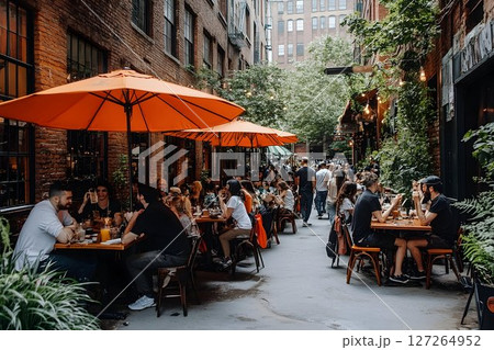 Vibrant outdoor dining scene with people enjoying meals on a bustling patio 127264952