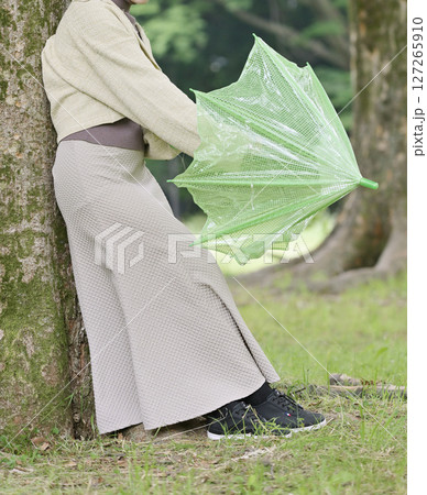 木の下で雨宿りする日本人の女性 木の下で雨宿りする日本人の女性 127265910