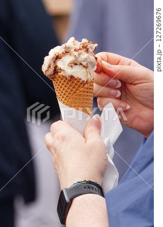Hand holding ice cream cone outdoors 127269676