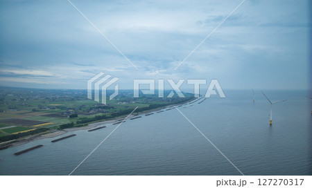梅雨空の富山県朝日町沿岸から見た笹川地区や入善町沿岸の洋上風力発電風車や小川河口の様子 127270317