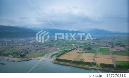 梅雨空の富山県朝日町沿岸から見た笹川地区や入善町沿岸の洋上風力発電風車や小川河口の様子 127270318