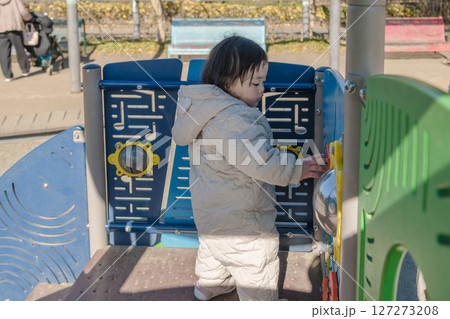 【相模原市立麻溝公園の子どもの広場の滑り台で遊ぶ1歳児】 127273208