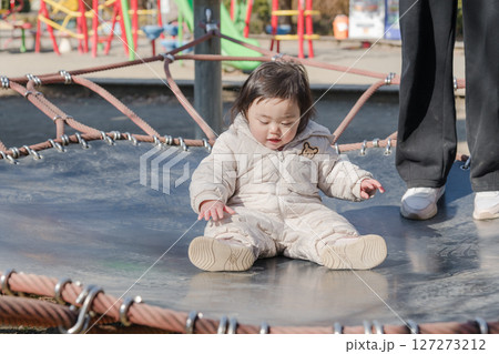 【相模原市立麻溝公園の子どもの広場のトランポリンでママと遊ぶ1歳児】 127273212