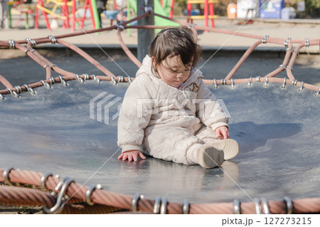 【相模原市立麻溝公園の子どもの広場のトランポリンで遊ぶ1歳児】 127273215