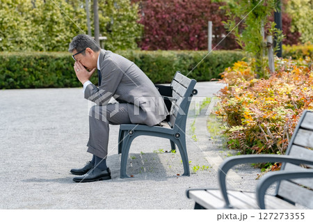 ベンチに座って悩むビジネスマン 127273355