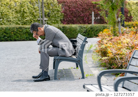 ベンチに座って悩むビジネスマン 127273357