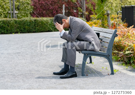 ベンチに座って悩むビジネスマン ベンチに座って悩むビジネスマン 127273360