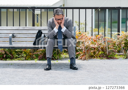 ベンチに座って悩むビジネスマン 127273366