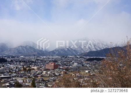 大町市越しに雲に隠された北アルプスの山々を望む 127273648