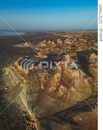 Aerial view of Aktumsuk cape's vibrant ridges under a clear blue Uzbekistan sky Aerial view of Aktumsuk cape's vibrant ridges under a clear blue Uzbekistan sky 127275667