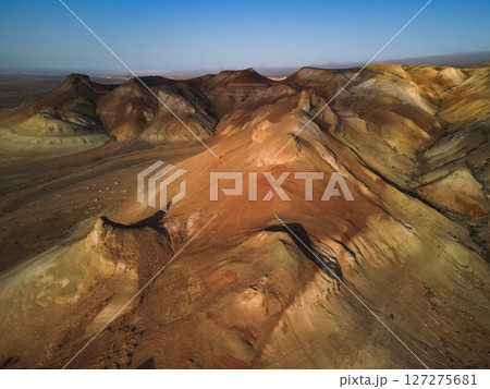 Curved crest of Aktumsik Cape reveals geological bands above vast desert plain Curved crest of Aktumsik Cape reveals geological bands above vast desert plain 127275681