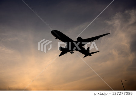 夕空に飛行機 127277089