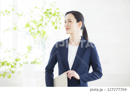 ノートパソコンを持つ笑顔のビジネスウーマン ノートパソコンを持つ笑顔のビジネスウーマン 127277704
