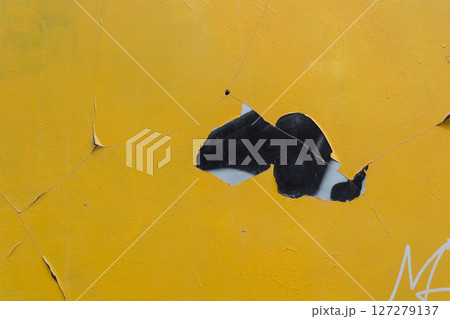 A yellow wall with a black and white graffiti on it A yellow wall with a black and white graffiti on it 127279137