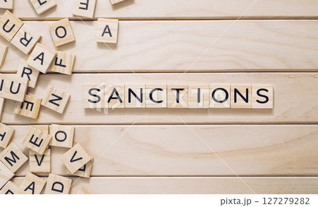 A wooden board with a jumble of letters scattered across it 127279282