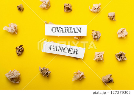 A yellow background with two pieces of paper that say Ovarian Cancer 127279303